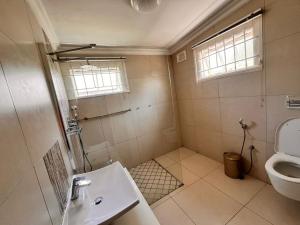 a bathroom with a shower and a sink and a toilet at Nsimbini 430 Lena Ahrens in Durban