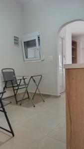 mesa y sillas en una habitación con espejo en Timbaki Theodosia T Brothers, en Tympáki