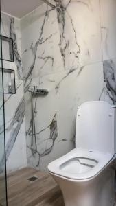 baño con aseo blanco y paredes de mármol en Timbaki Theodosia T Brothers, en Tympáki 14 fotos más