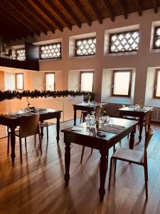 a dining room with tables and chairs and windows at Casale Riversa in Poncarale +22 photos