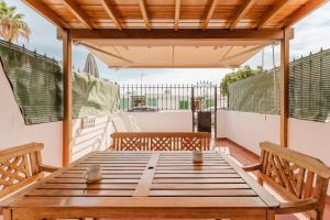 een patio met een houten tafel en 2 banken bij Playa Chica apartment in Puerto del Carmen