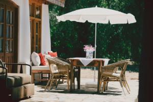 un tavolo con sedie e un ombrellone in un patio di Bitez Village Room a Bodrum City