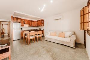 een woonkamer met een witte bank en een keuken bij Playa Chica apartment in Puerto del Carmen +8 foto's