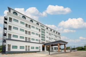 a white building with a bus stop in front of it at Finn Hotel in Ban Fang Daeng