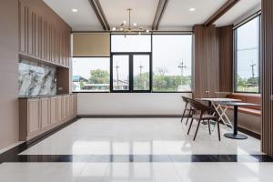 a dining room with a table and chairs and windows at Finn Hotel in Ban Fang Daeng