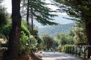 a woman walking down a path in a blue dress at Be Vedetta - Relais & Glamping - Adult Only in Scarlino +88 photos