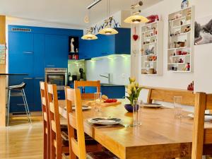 comedor con mesa de madera y armarios azules en Eiger Residence 3, en Wengen