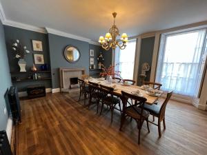 una sala da pranzo con tavolo, sedie e lampadario di Ash House a Wincanton