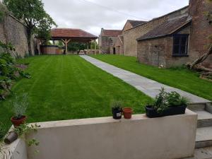 un giardino con piante in vaso su un muro di Ash House a Wincanton