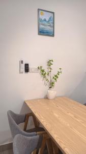 a wooden table with a vase with a plant on it at Amber Cove - Luxury Design By Luxpro Management - 6~7 pax in Melaka