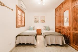 twee bedden in een kamer met witte muren bij Playa Chica apartment in Puerto del Carmen