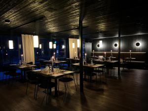 Un comedor con mesas, sillas y luces. en Silver Birch Resort Lapland, en Rovaniemi