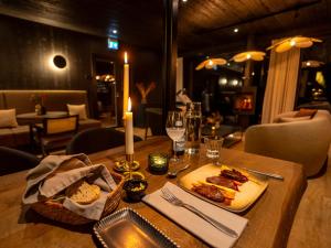 una mesa con un plato de comida y velas en Silver Birch Resort Lapland, en Rovaniemi 27 fotos más