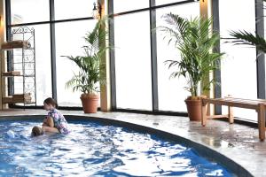 a little girl sitting in a hot tub in a building at Marritz Hotel in Perisher Valley