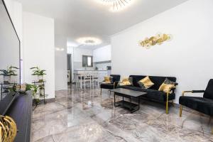 a living room with black couches and a table at הפנינה של סוניה in Haifa