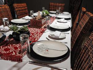 a long table with plates and napkins on it at Mazuri Shamba Lodge in Phalaborwa