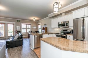 a kitchen with white cabinets and stainless steel appliances at The Wine Barrel - Shuttle to Blue & Private Patio in Collingwood
