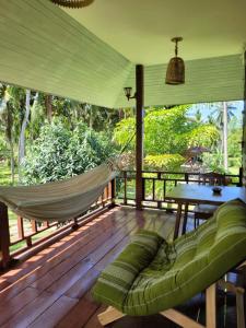 a hammock on a screened in porch with a hammock at Nazo Boutique Bungalows in Wok Tum