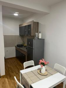 a small kitchen with a table and a refrigerator at S&B Apartman Vrnjačka Banja in Vrnjačka Banja