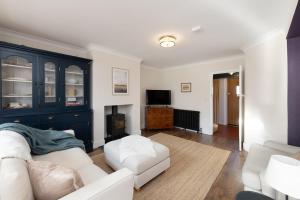 a living room with a white couch and a tv at Oxfordshire Country Escape, 3 Bed Getaway in Long Wittenham