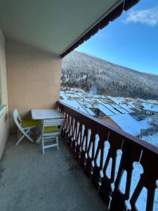 ein Balkon mit Tisch und Blick auf eine Stadt in der Unterkunft Appartement cosy quartier Napoléon in Val Cenis