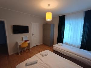 une chambre avec deux lits et un bureau avec un ordinateur dans l'établissement Willa Cieszynianka, à Wisła