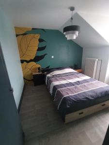 a bedroom with a large bed with a green wall at Au Logis du Mont in Belfort
