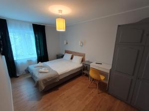 a bedroom with a bed and a desk and a chair at Willa Cieszynianka in Wisła