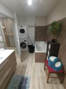a small bathroom with a washing machine and a chair at Au Logis du Mont in Belfort