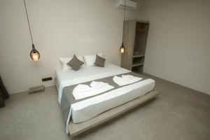 a bedroom with a bed with white sheets and pillows at Nico Villa in Ahangama