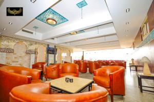 a restaurant with orange chairs and a table and a table and chairs at Giza Inn Comfort view in Cairo