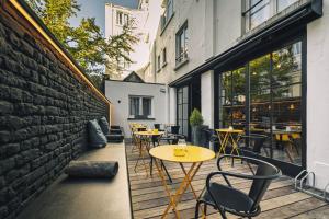 un patio con tavoli e sedie accanto a un muro di mattoni di Zoom Hotel a Bruxelles