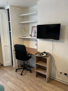 Elle comprend un bureau avec une chaise et une télévision murale. dans l'établissement Studio - Le Bourgogne 21, à Orléans