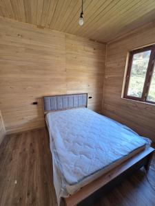 a bed in a room with a wooden wall at SkyGona in Ghebi