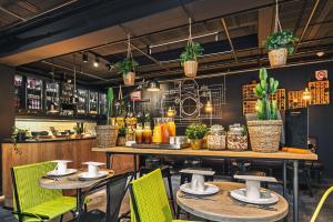 un ristorante con tavoli, sedie e piante di Zoom Hotel a Bruxelles