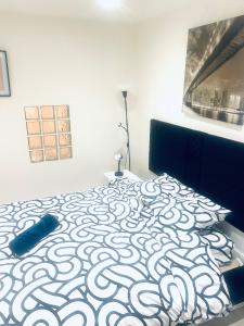 a bedroom with a bed with a black and white pattern at F2 Escale CDG calme à 20 mins de paris , Stade 2 France, Aéro CDG, Parc des expositions, Disneyland Paris,Futuroscope, Tour Eiffel in Arnouville-lès-Gonesse