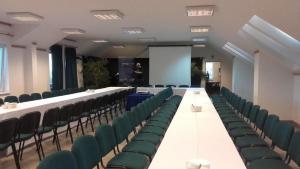 a conference room with a long table and green chairs at MOSiR Reda in Reda