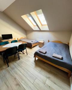 a bedroom with two beds and a desk and a table at MOSiR Reda in Reda