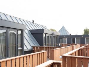 uma fileira de casas modulares com decks de madeira em Luxury apartment in Renesse with infrared sauna em Renesse