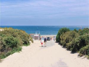 um grupo de pessoas caminhando por uma praia de areia em Luxury apartment in Renesse with infrared sauna em Renesse