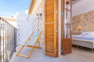 a room with a balcony with a wooden door and a bed at Cas Català in Sineu +93 photos