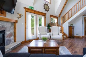 un soggiorno con 2 sedie bianche e un camino di Still Winds - Private Patio - Shuttle to Blue a Collingwood