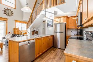 una cucina con mobili in legno e un frigorifero in acciaio inossidabile di Still Winds - Private Patio - Shuttle to Blue a Collingwood