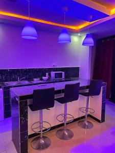 a kitchen with purple lighting and a bar with stools at Classimo in Dakar