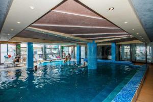 a large swimming pool with people in the water at Pirin's Hidden Gem BB & SKI & SPA in Bansko