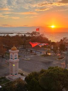 a clock tower with the sunset in the background at Tekirdağ Yat Hotel in Tekirdag