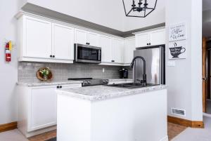 una cucina bianca con lavello e frigorifero di Snowy Mountain Summit & Sol - Shuttle - Patio a Collingwood