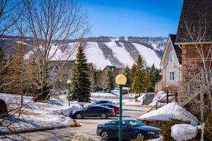 due auto parcheggiate in un parcheggio nella neve di Snowy Mountain Summit & Sol - Shuttle - Patio a Collingwood