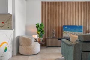 un soggiorno con una sedia e un divano di Luxury 3BR Garden Apartment Estepona a Estepona