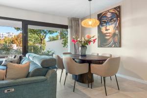 un soggiorno con un divano e un tavolo di Luxury 3BR Garden Apartment Estepona a Estepona